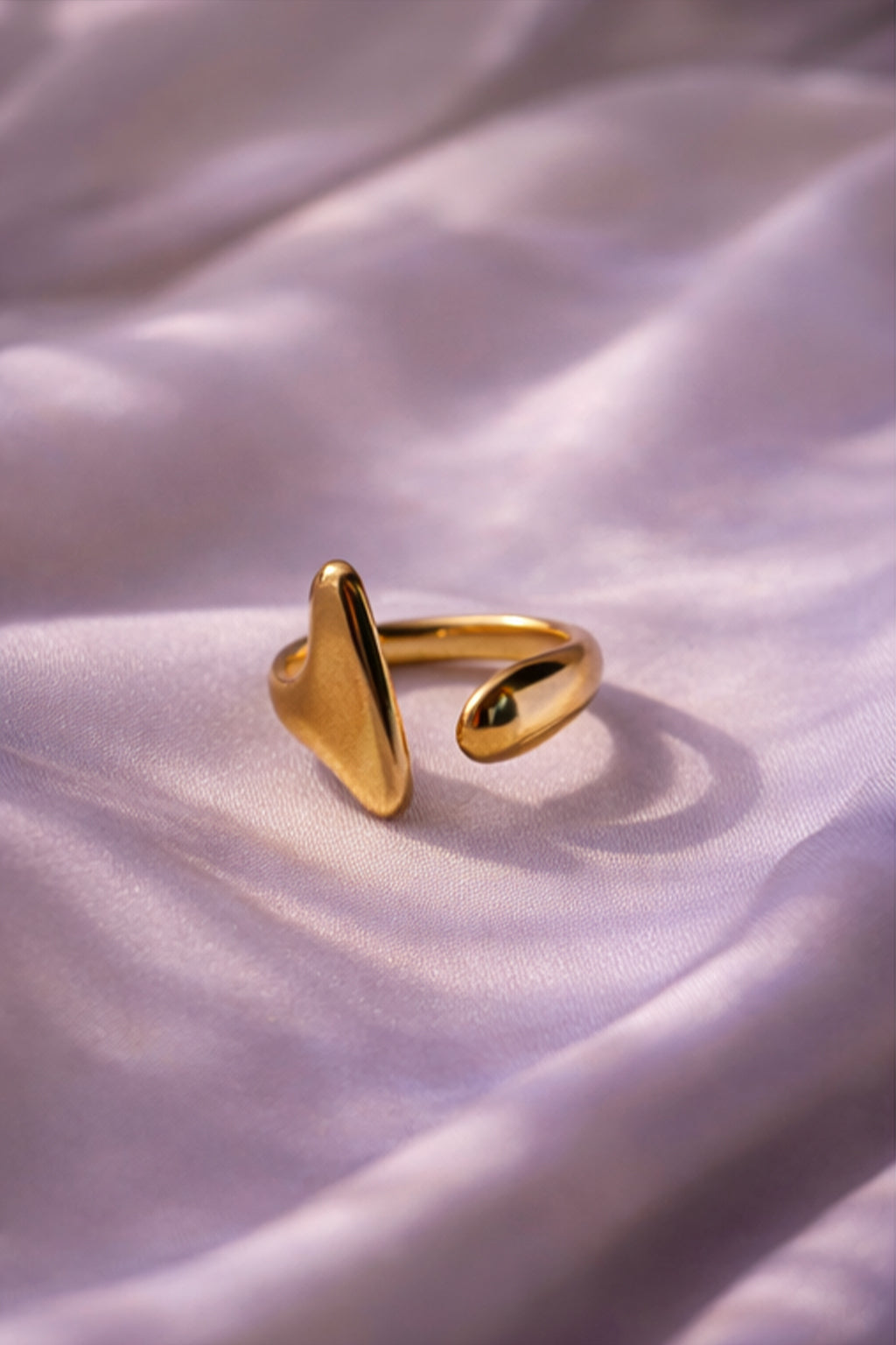 Gold ring on a soft, light-colored fabric background