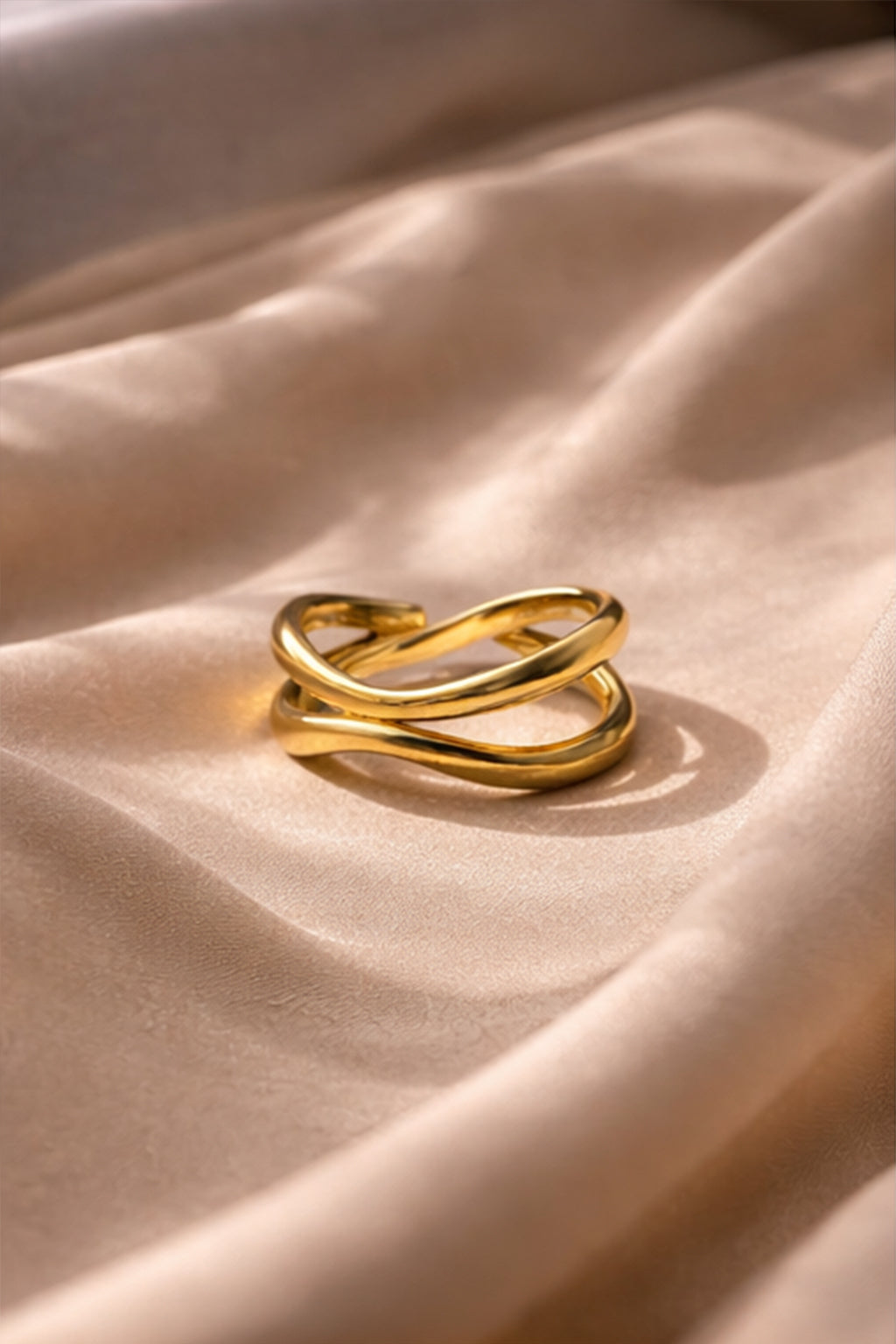 Two gold rings on a beige fabric surface